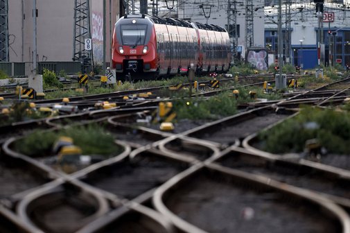 Eine Regionalbahn fährt am Kölner Hauptbahnhof, man sieht zahlreiche Gleise und Weichen der Strecke.
