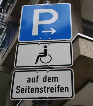 Ein Schild mit einem P und einem Rollstuhlfahrer für einen Behindertenparkplatz