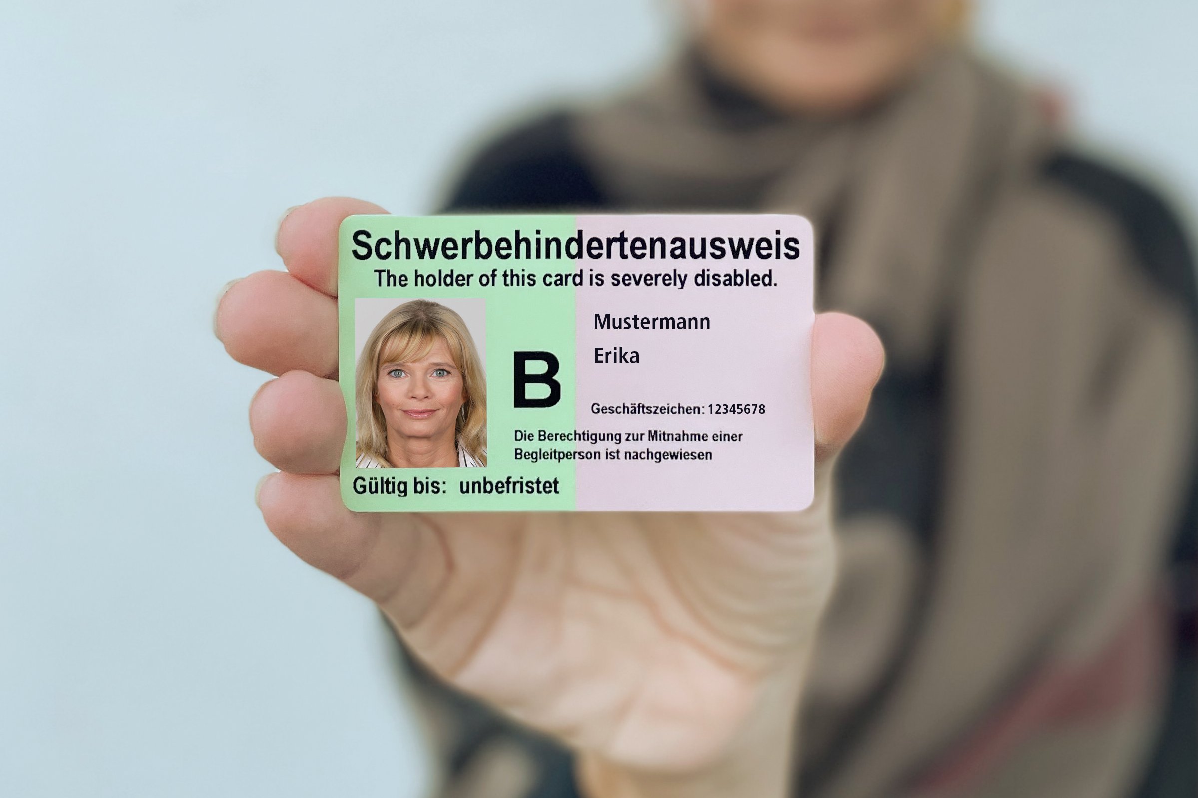 Eine Frau zeigt einen Schwerbehindertenausweis.