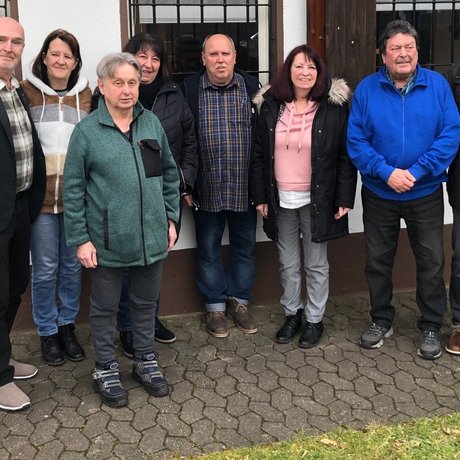 Eine Gruppe Menschen steht vor einem Haus