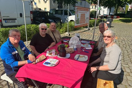 Gruppe von f&uuml;nf Personen nach dem Aufbau beim Fr&uuml;hst&uuml;ck
